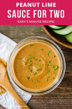 peanut lime sauce for two in a glass bowl with a wooden spoon next to it