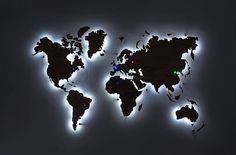 an illuminated world map is shown in the dark with white lights on it's sides