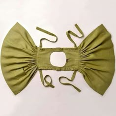 a green bow tie on top of a white surface with a pair of scissors next to it