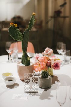 a table topped with a potted cactus and flowers