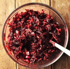 a glass bowl filled with cranberry sauce on top of a wooden table