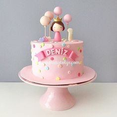 a pink birthday cake with polka dots and a princess figure on top that says deniz