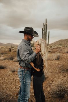 a man and woman standing next to each other in the desert