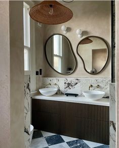 a bathroom with two sinks and mirrors on the wall