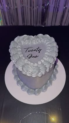 a heart shaped cake with the words twenty one written on it in cursive writing