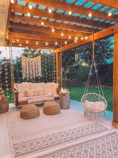 an outdoor living area is lit up with string lights and hanging furniture, including a swing chair