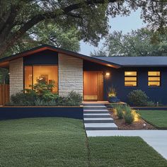 a blue house with steps leading up to it's front door and landscaping area