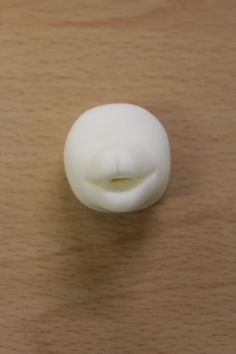 a white plastic object sitting on top of a wooden table