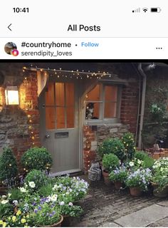 an image of a house that is decorated with flowers and potted plants on the front porch