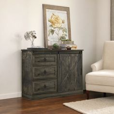 a white chair sitting next to a wooden cabinet in a living room on top of a hard wood floor