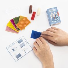 someone is making a birthday cake out of legos and other crafting supplies on a table