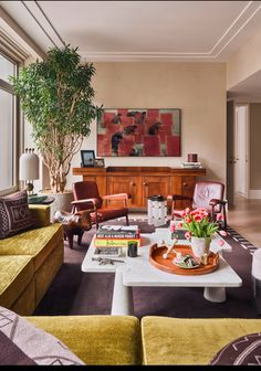 a living room filled with furniture and a potted plant on top of a coffee table