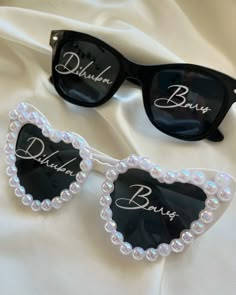 two pairs of sunglasses with the name braun on them and pearls in front of them