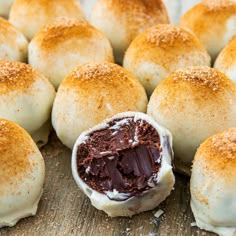 rolls filled with chocolate and sprinkled with powdered sugar on a cutting board