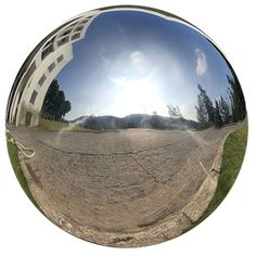 an image of the reflection of a building in a ball that looks like it's going to fall