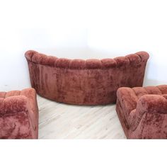 three red velvet couches sitting on top of a wooden floor next to each other