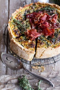 a quiche on a wire rack with a serving spoon