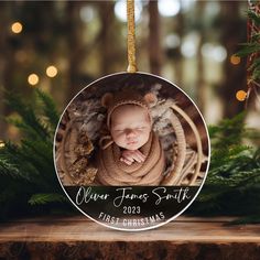 a baby's first christmas ornament hanging from a tree