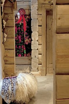 an animal that is standing in front of some wood walls and door way to another room