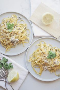 two plates of spaghetti with lemon and parsley