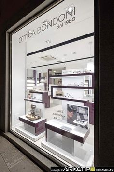 a store front window with many items on display in the glass and behind it is a sign that says ottica bondo