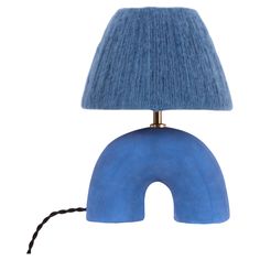 a table lamp with a blue shade on the base and a black cord attached to it