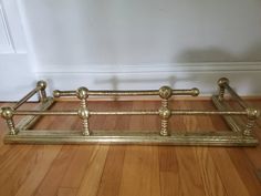 a gold metal bed frame sitting on top of a wooden floor