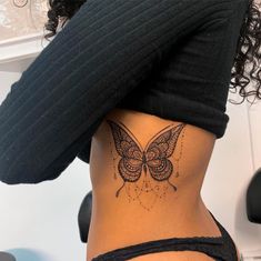 a woman with a butterfly tattoo on her stomach