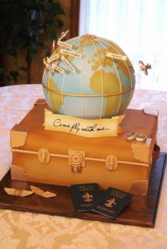 a cake made to look like an old suitcase with a globe on top and luggage tags around it