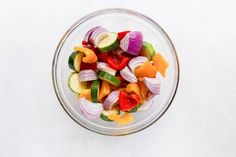 a glass bowl filled with sliced up vegetables