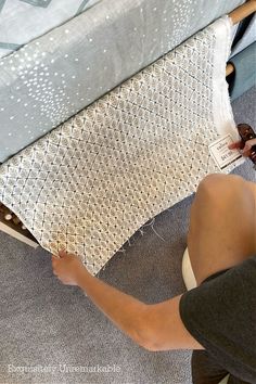 a person is painting the bottom of a bed with white paint and silver foil on it