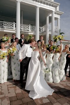 a group of people standing next to each other in front of a building with columns