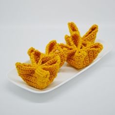 two crocheted yellow bows on a white plate