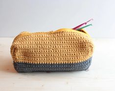 a crocheted pencil case sitting on top of a wooden table