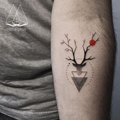 a man's arm with a deer head and triangle tattoo on the left forearm