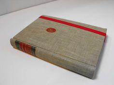 an old book with red ribbon on it sitting on top of a white countertop