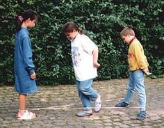 three young children are walking down the street