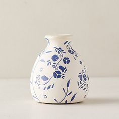 a white and blue vase sitting on top of a table