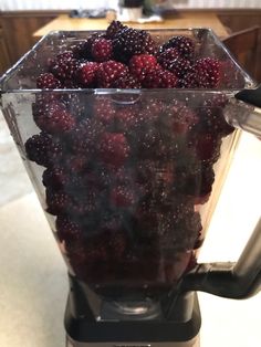 a blender filled with berries sitting on top of a counter