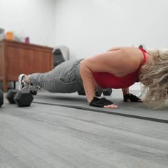 a woman is doing push ups on the floor