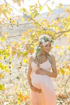 a pregnant woman with flowers in her hair and the caption before i knew you, i carried you under my heart