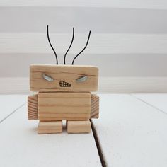 a small wooden toy with eyes and antennae