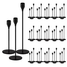 a bunch of black candles are lined up in rows and placed on pedestals for display