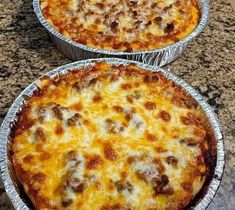 two pizza pies sitting on top of a counter