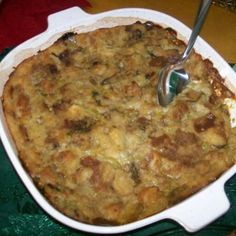 a casserole dish with meat and vegetables in it on a green tablecloth