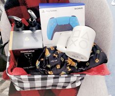 the contents of a man's gift basket sitting on a chair in front of a plaid blanket