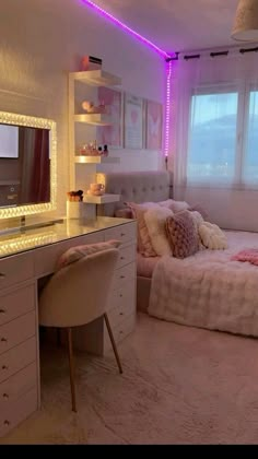 a bedroom with a bed, desk and mirror in it's corner next to a window