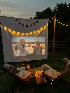 an outdoor movie screen with two people on it