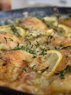 chicken with lemons and herbs in a pan