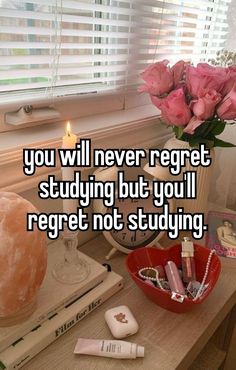 a table with flowers, candles and books on it that says you will never regret studying but